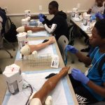 Biotech students learning to draw blood at Drexel simulation lab